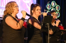 Trzy kobiety śpiewają do mikrofonów