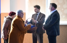 Dwóch elegancko ubranych mężczyzn trzyma kosz z poczęstunkiem dla kobiet